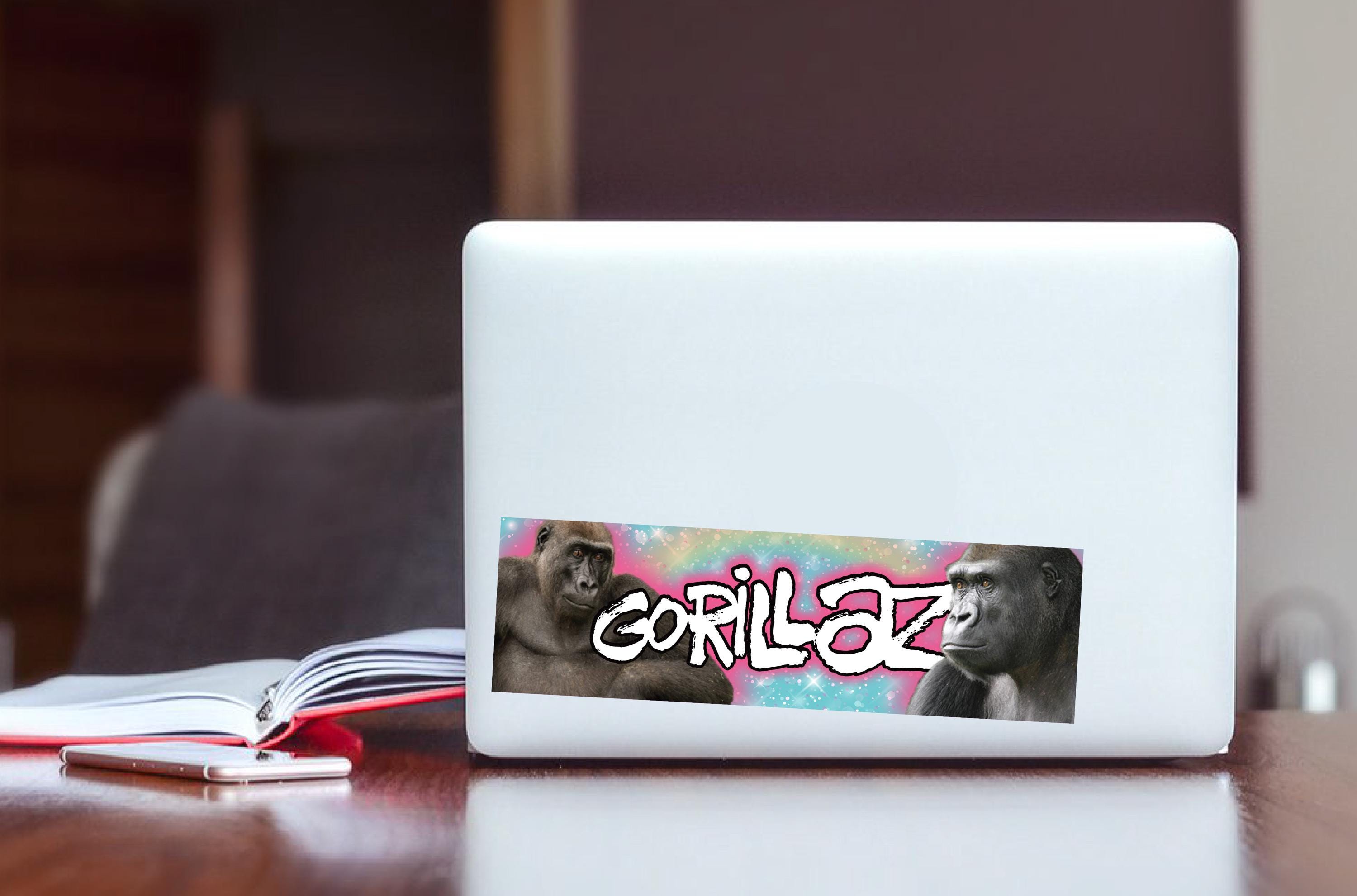 Laptop with a gorilla-themed sticker on a wooden surface