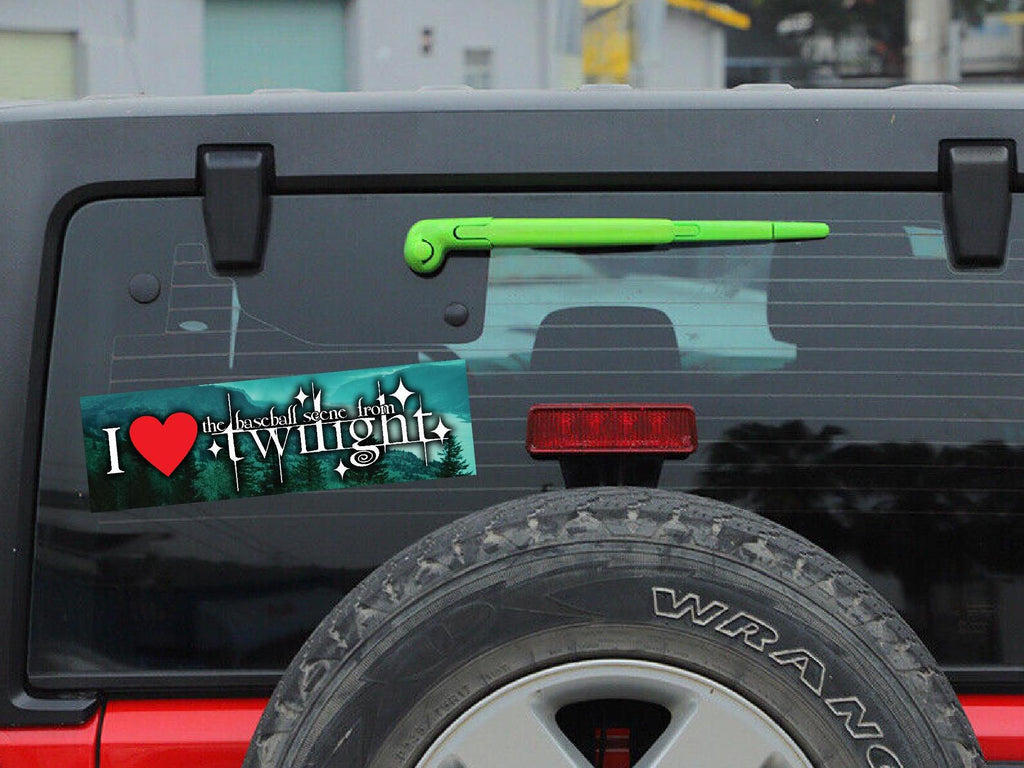 Back of a black Jeep Wrangler with 'I ❤️ Twilight' bumper sticker and green tool on tailgate.