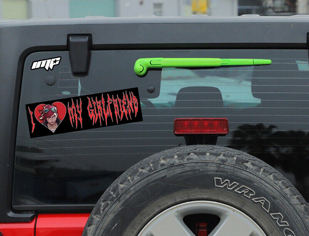 Back of a black Jeep Wrangler with a 'I Heart My Girlfriend' decal and green antenna.