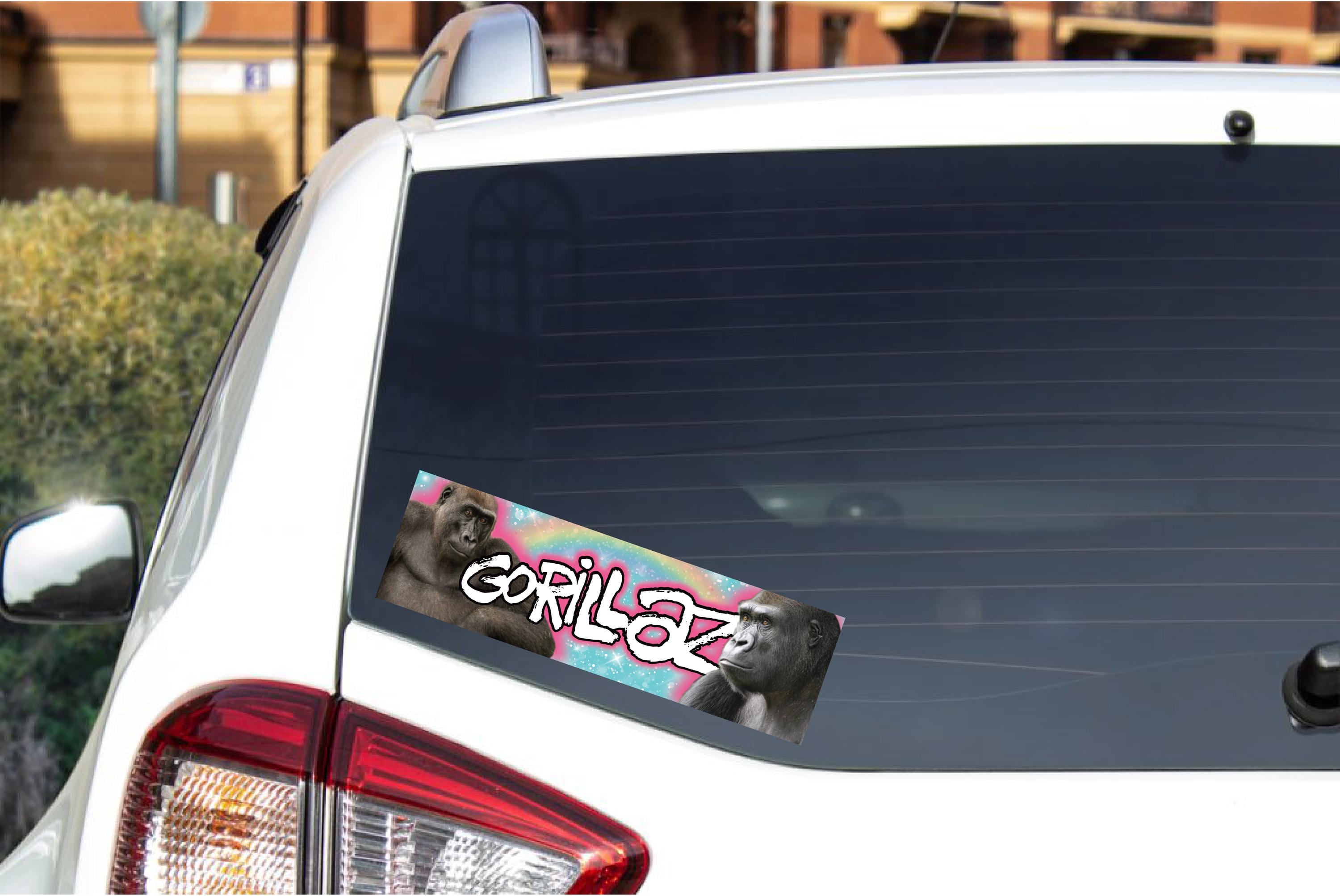 Car window with a 'Gorillaz' sticker on a white car