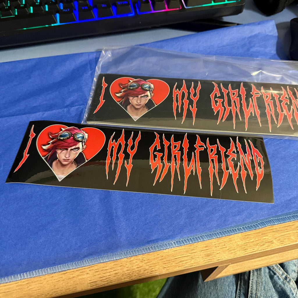 Two bumper stickers with a graphic of vi arcane with red hair and text on a blue surface.